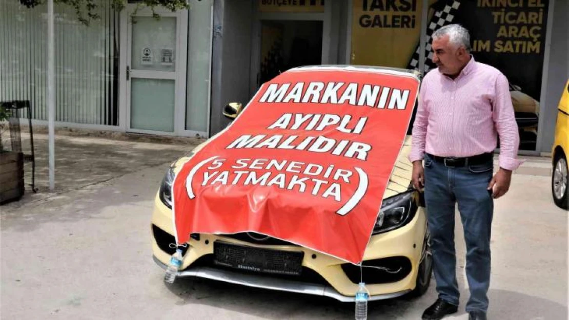 Aldığı lüks aracı işyerinin önüne koyup, üzerine 'Markanın ayıplı malıdır, 5 yıldır yatmakta' yazdı