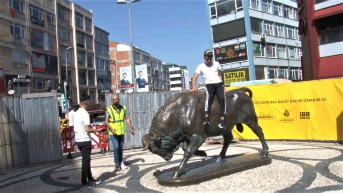 Kadıköy'de, bakıma alınan Boğa Heykeli'nin üzerine çıkıp fotoğraf çektirdi