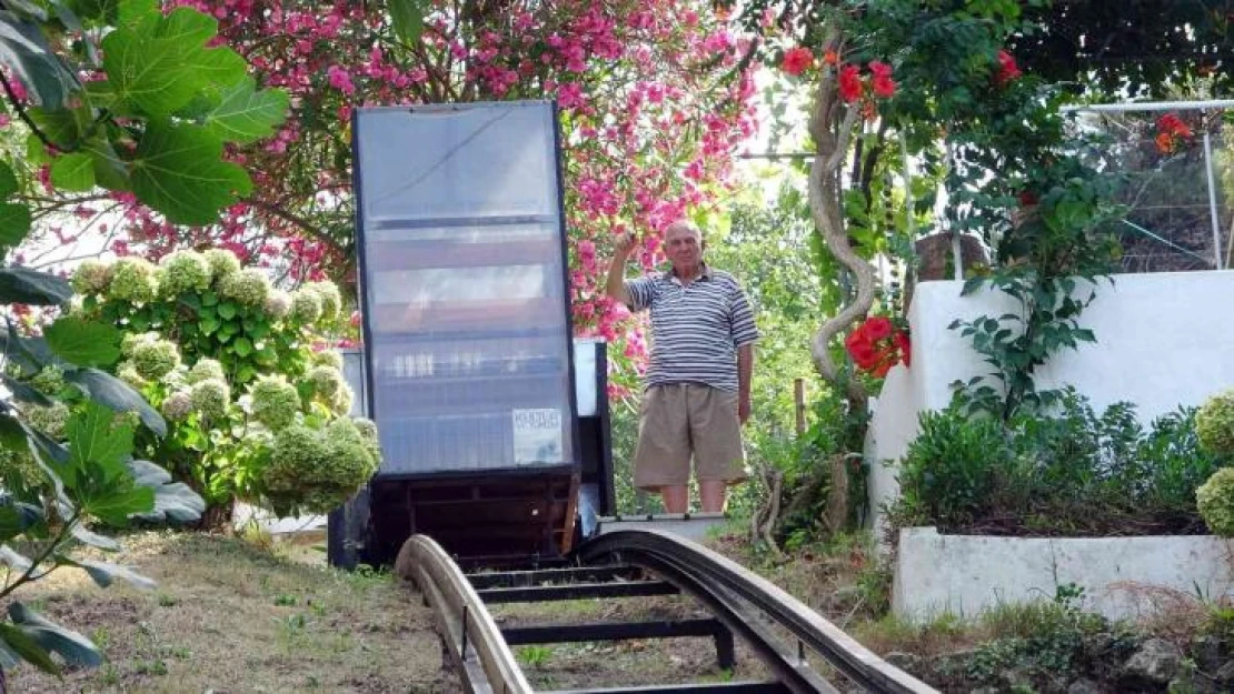 Yokuşun başındaki evine kurduğu raylı sistemle gidiyor