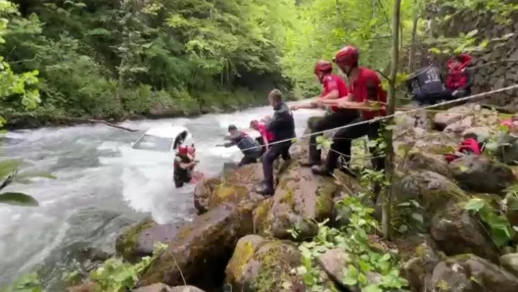Rize'de dereye uçan aracın üzerine çıkarak yardım beklediler